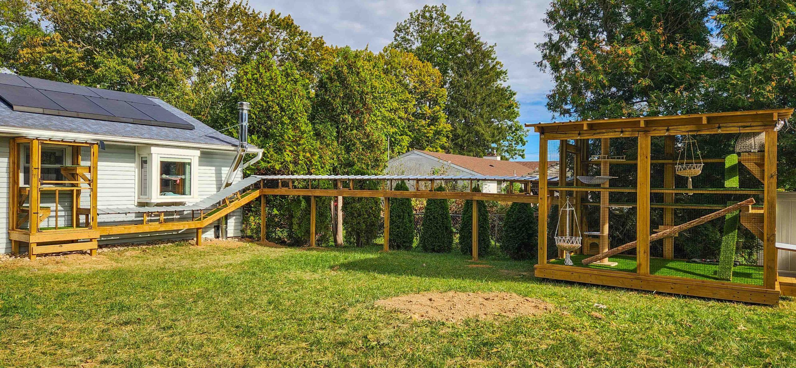 Backyard catio system connected to house by a long enclosed tunnel walkway.
