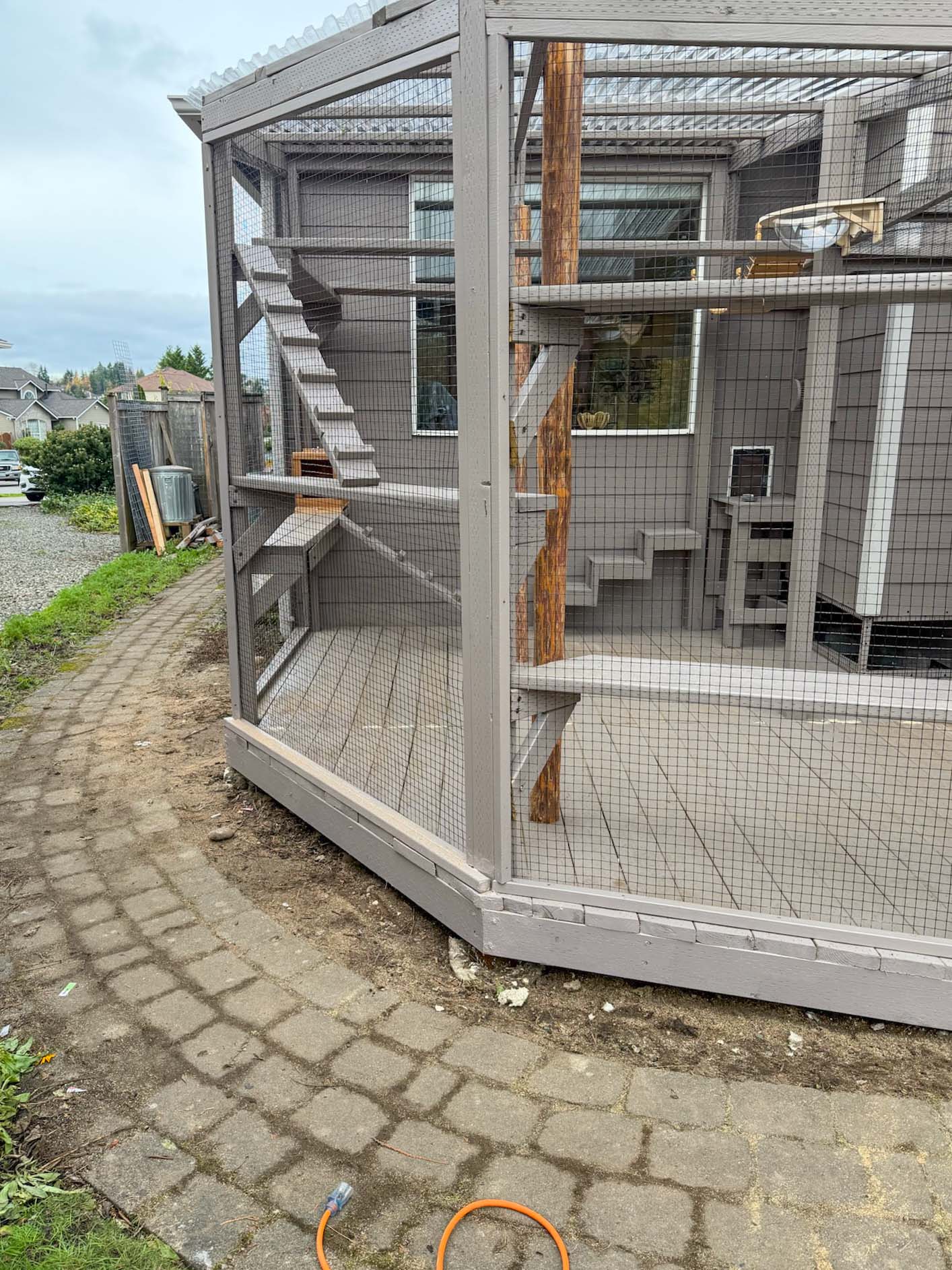 Exterior view of custom catio showing its angled design and elevated platforms inside.