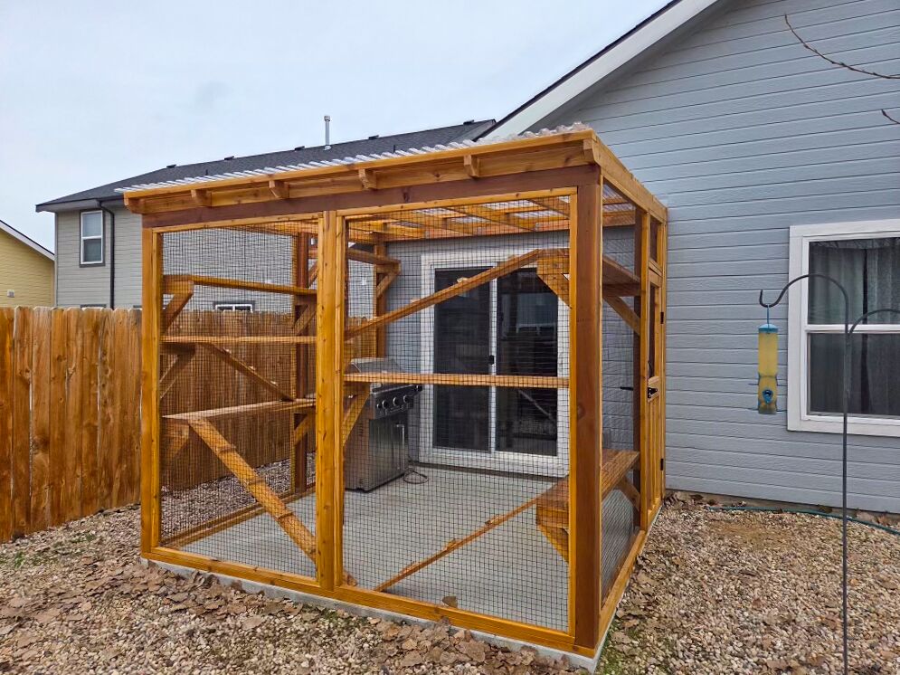 Wide angle of custom cedar catio with patio grill inside.