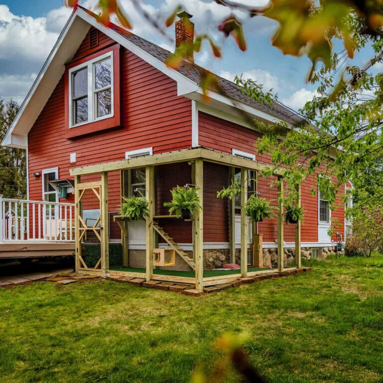 Red house with light-wood catio and hanging plants
