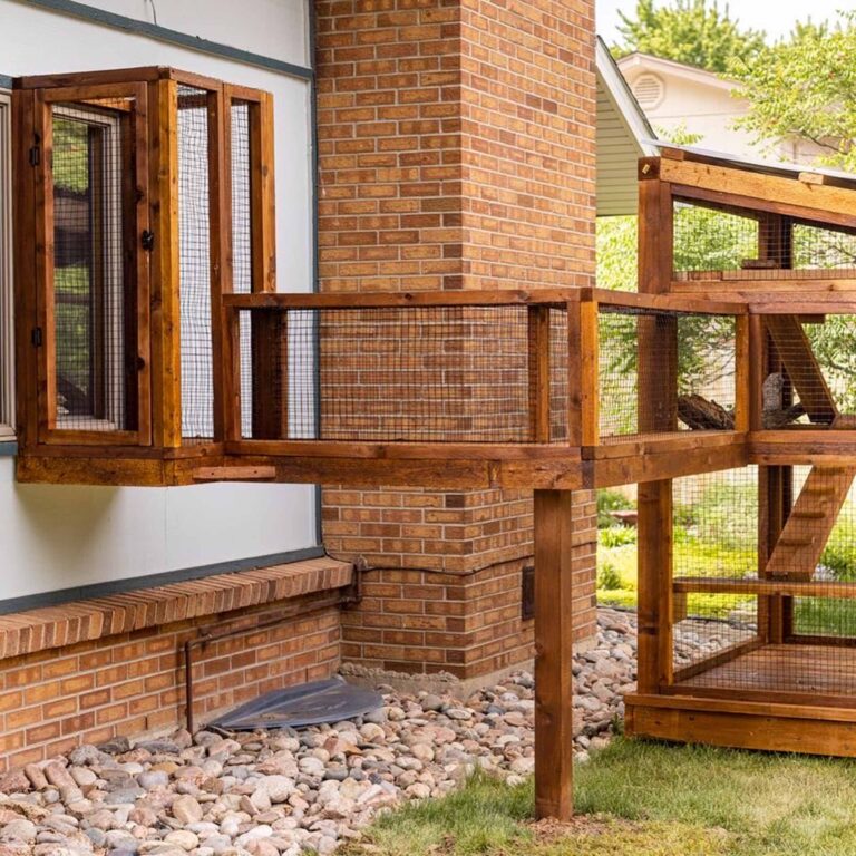Wooden catio connected to a house window, featuring an elevated tunnel and spacious lower enclosure with mesh walls.