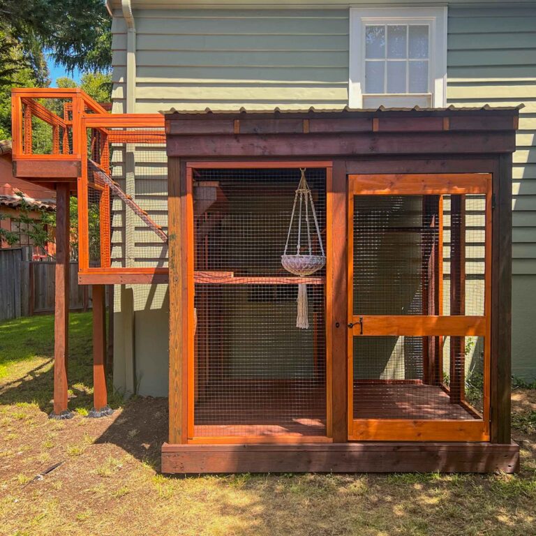 Backyard catio with pitched roof, tunnel entry, and hammock inside.