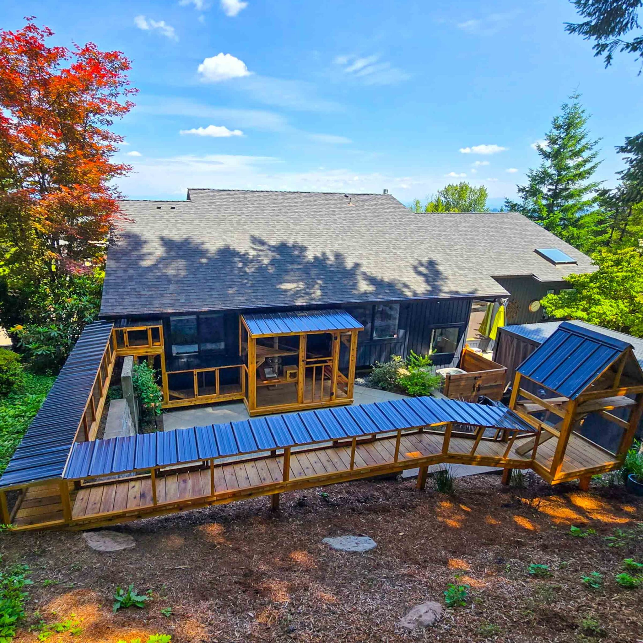 A large custom catio system with extended covered tunnels leading from the home into outdoor enclosures.