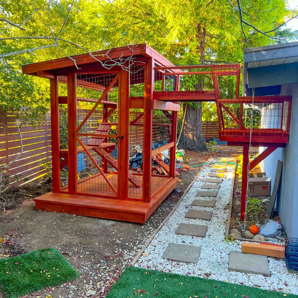 Elevated redwood catio with extended bridge tunnel leading from house