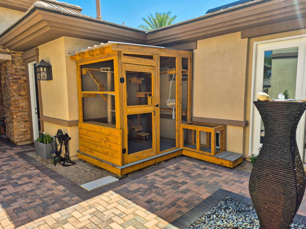 Compact wooden custom catio attached to a stucco home with a small window-entry enclosure.