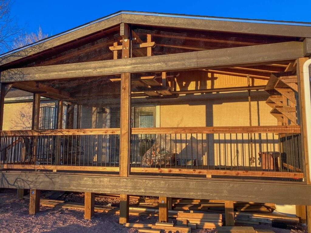 Large elevated custom catio exterior attached to a home in Pueblo Colorado with wood framing, wire mesh enclosure, ramp access, and spacious outdoor living area for cats